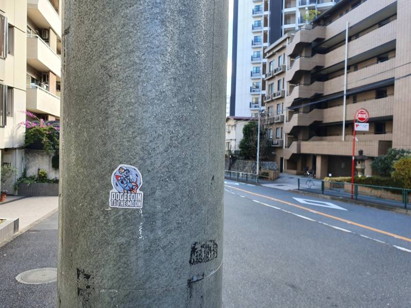 Dogecoin community sticker in Tokyo depicting digital currency ecosystem expansion