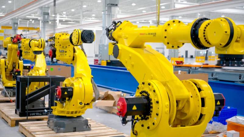 Fleet of wheeled autonomous delivery robots lined up on a testing track.